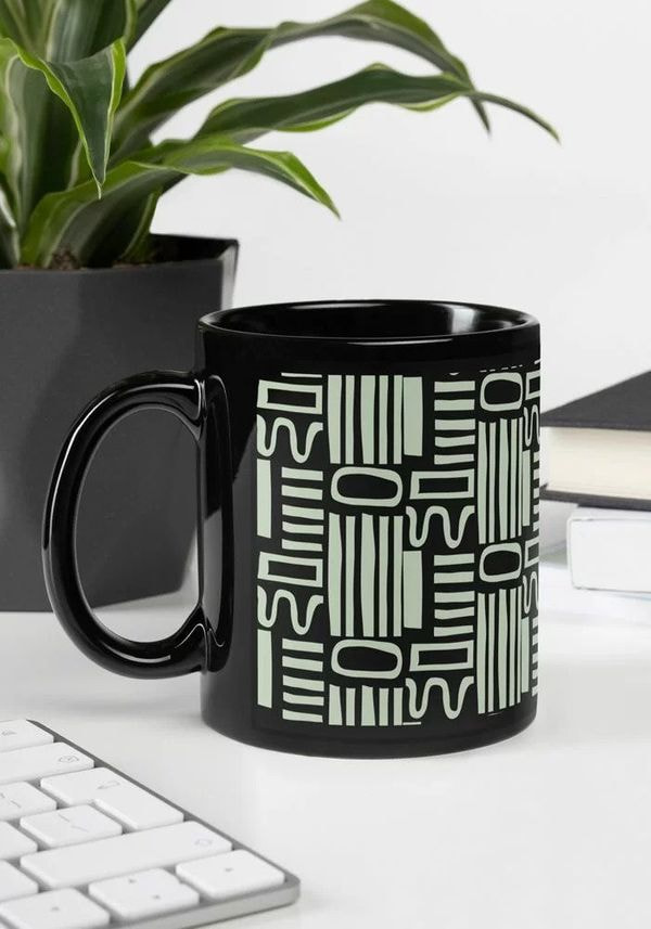 a black coffee mug with a white design on it